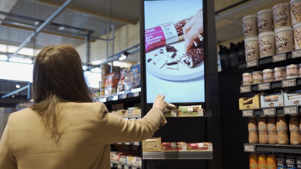 Frau vor Bodendisplay Spotlight mit Müsliriegeln