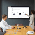 Frau präsentiert EMSU Portal auf großem Bildschirm in einem Meeting